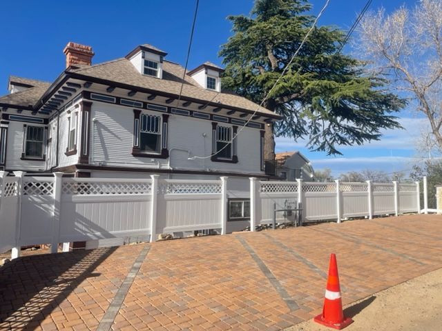 A white picket fence along a sidewalk in a residential neighborhood