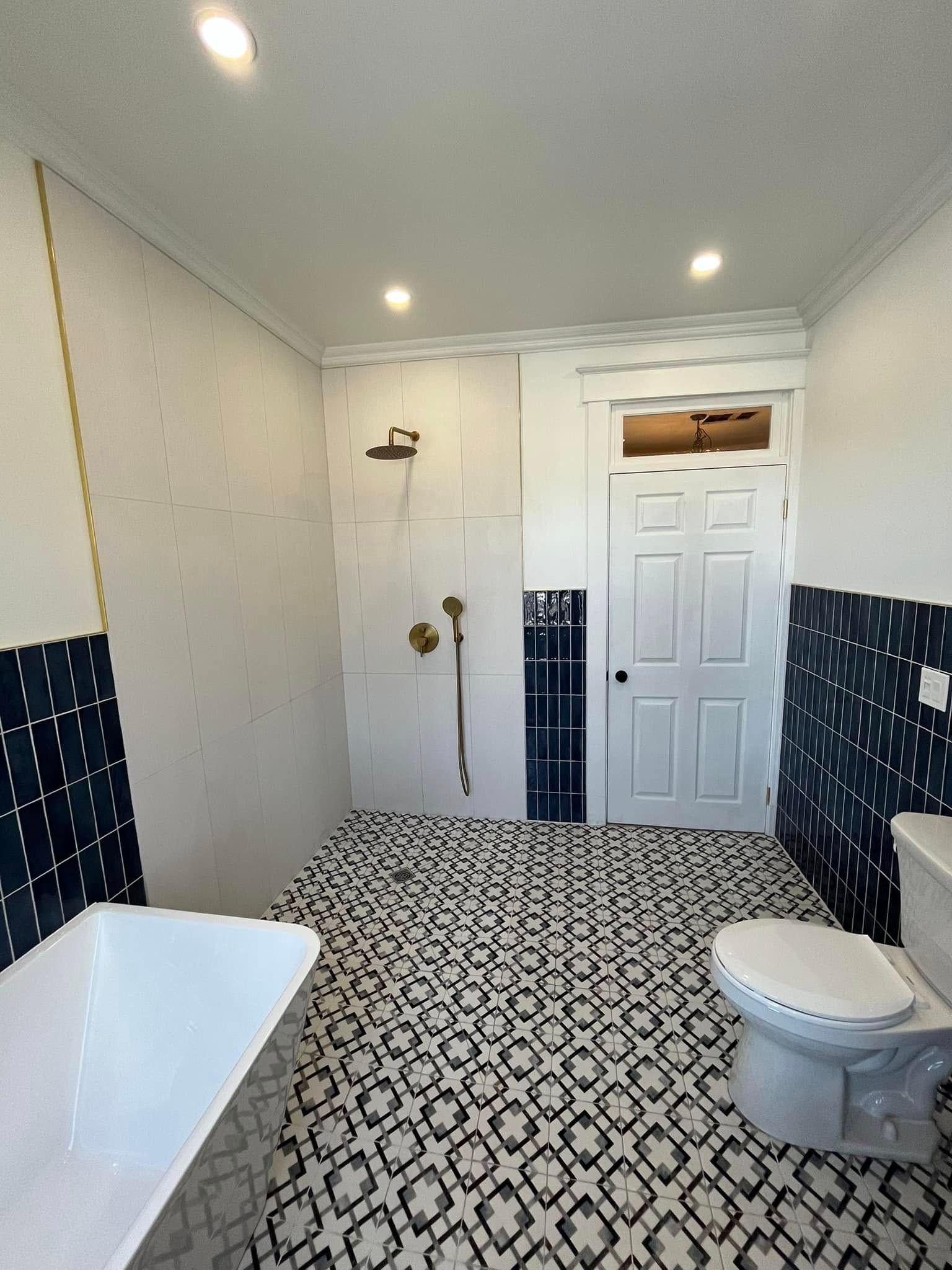 Une salle de bain avec baignoire, toilettes et douche.