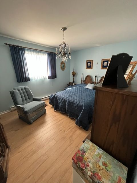 Une chambre avec un lit, une chaise et une commode