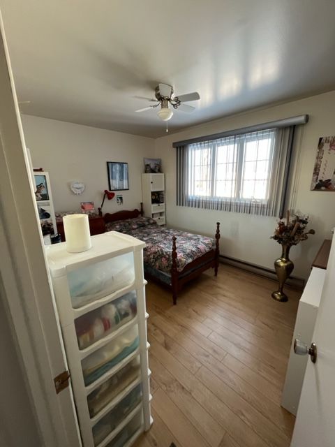 Une chambre avec un lit et un ventilateur de plafond