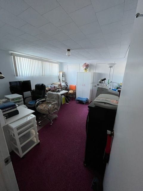 Une pièce avec un tapis violet et des murs blancs