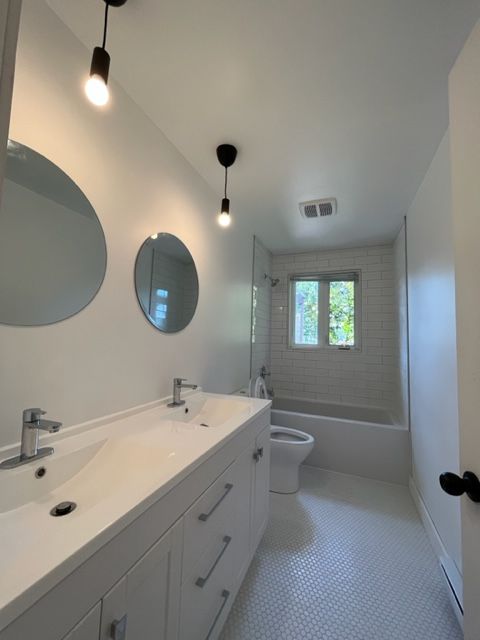 Une salle de bain avec deux lavabos un WC et une baignoire