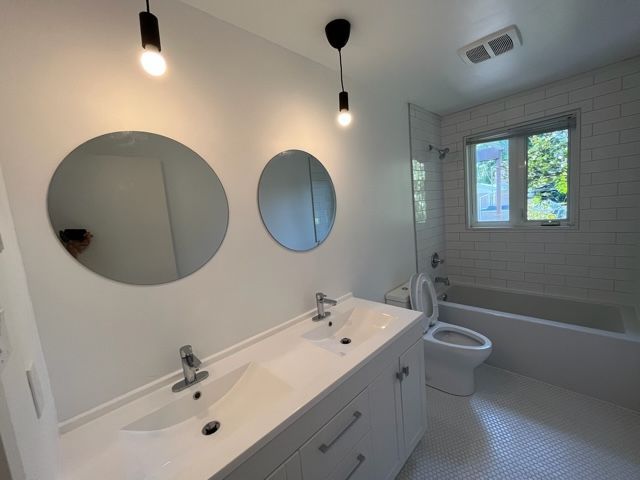 Une salle de bain avec deux lavabos et deux miroirs