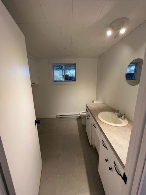 Une salle de bain avec lavabo, WC et miroir.