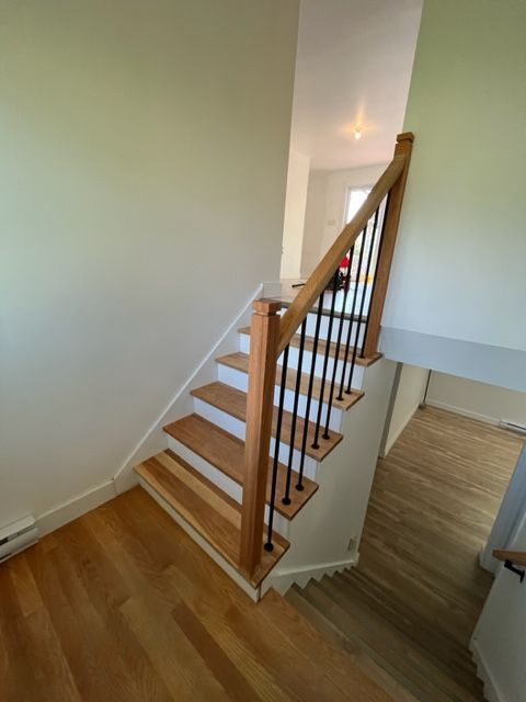 Un escalier en bois avec une rampe en métal dans une maison