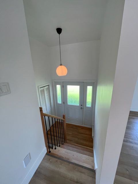 Un escalier menant à une porte avec une lumière suspendue au plafond.