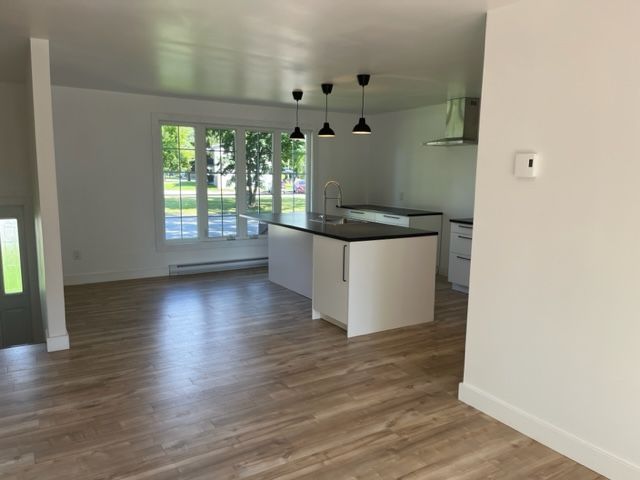 Une pièce vide avec du parquet et des murs blancs