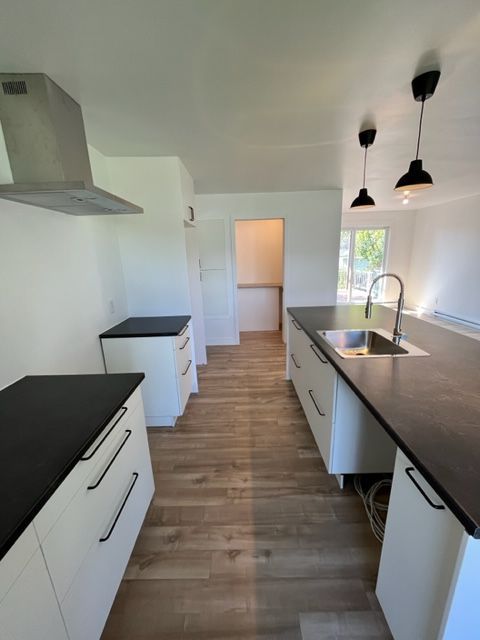 Une cuisine avec des comptoirs noirs et des armoires blanches