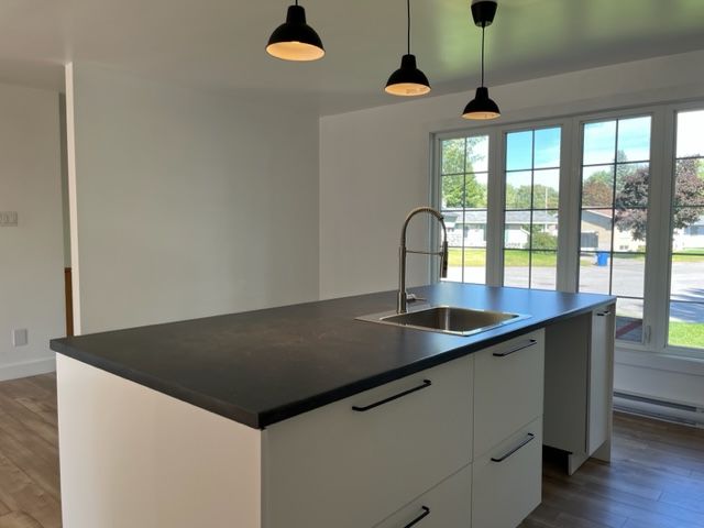 Une cuisine avec un grand îlot et un évier