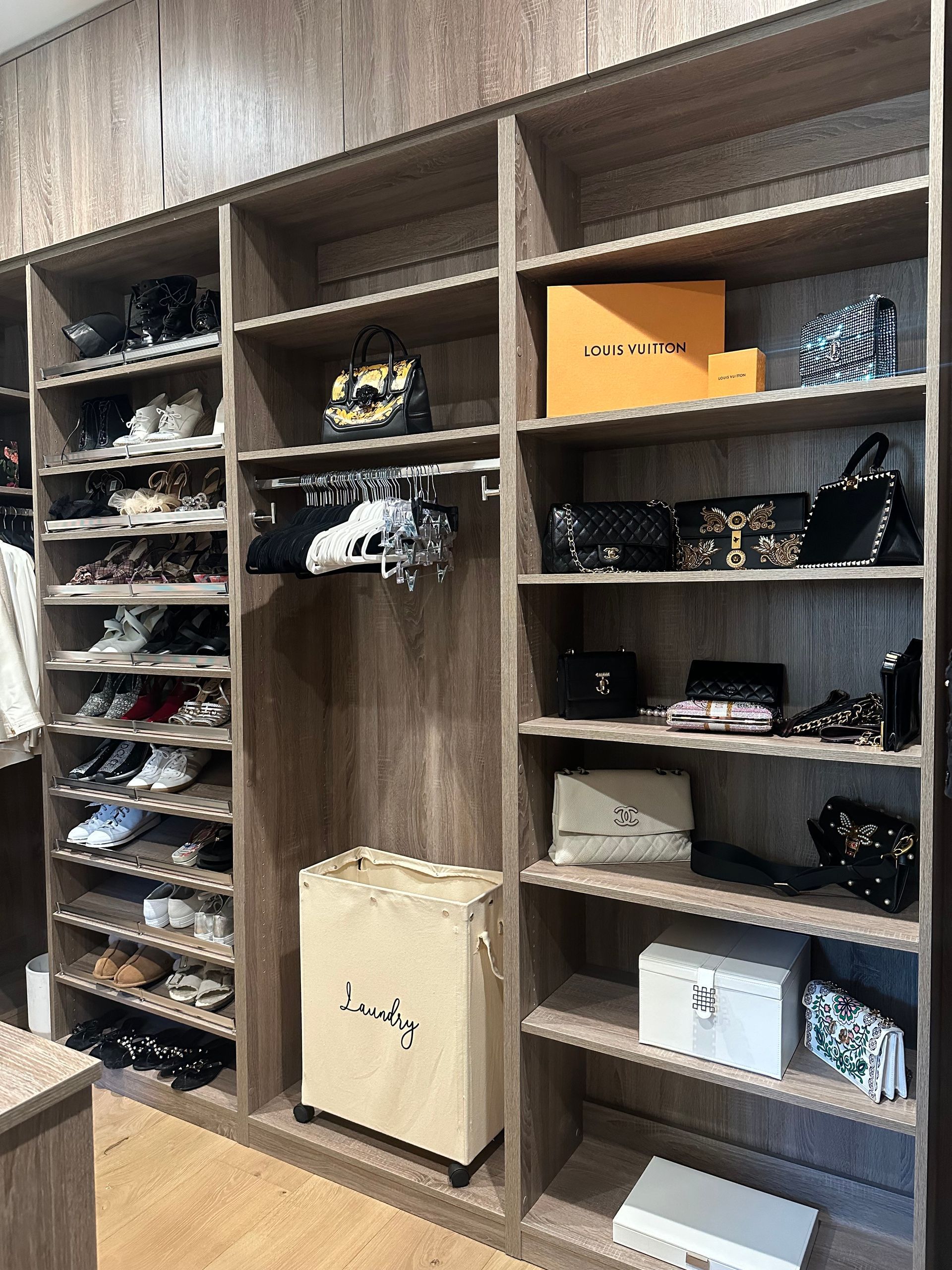 Closet organizer with shoes, handbags, and boxes on shelves, mostly shades of brown and beige.
