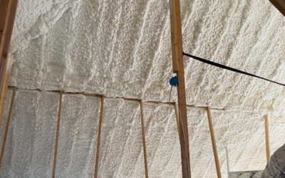 Spray foam insulation applied to the underside of a wooden attic roof structure.