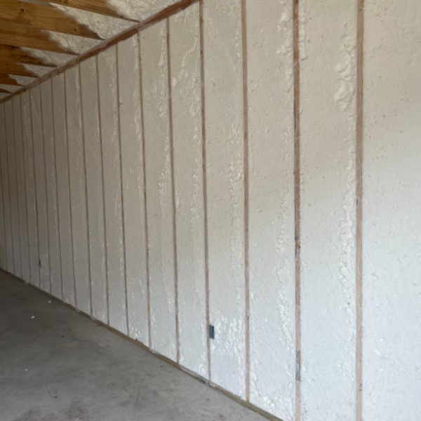 Wall studs with spray foam insulation installed in the wall cavities of an unfinished room.