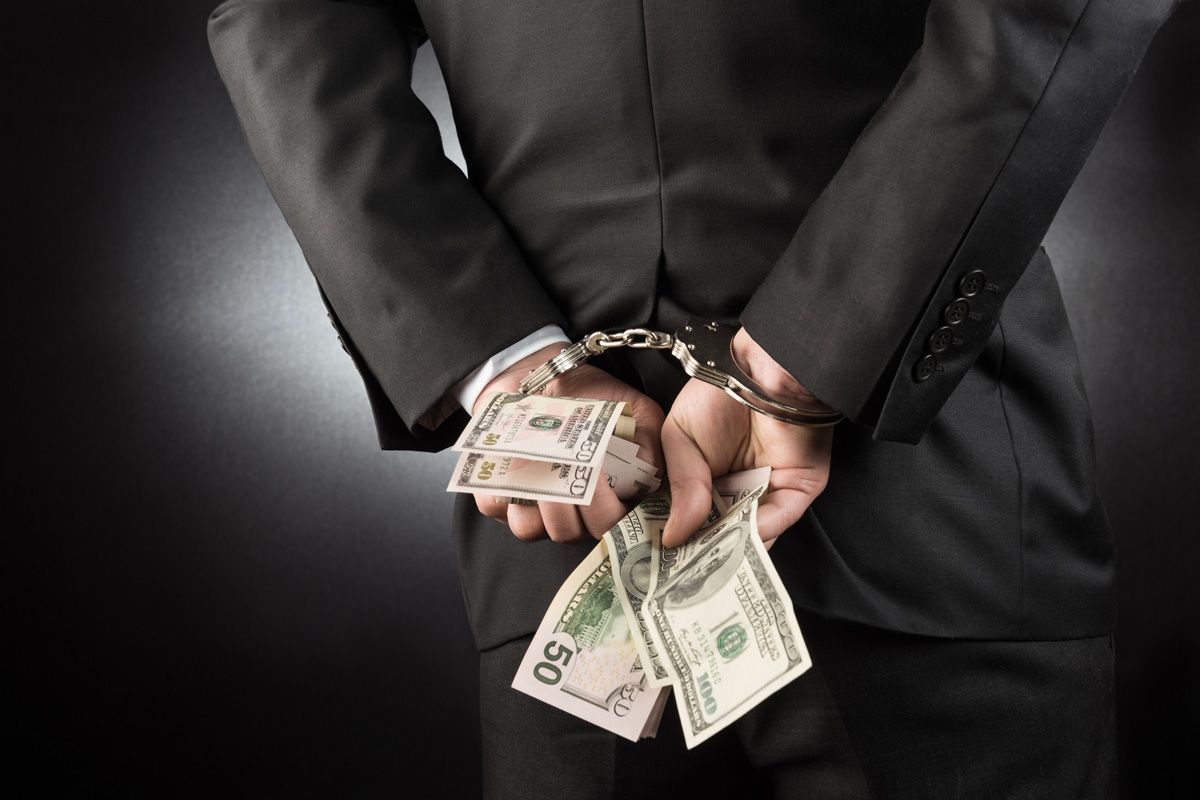 Businessman Handcuffed with Dollar — Yuba City, CA — Law Office of Geoffrey J. Heitman