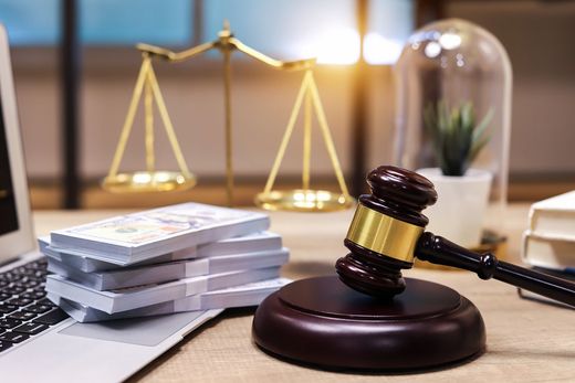 A judge 's gavel is sitting on a table next to a stack of money.