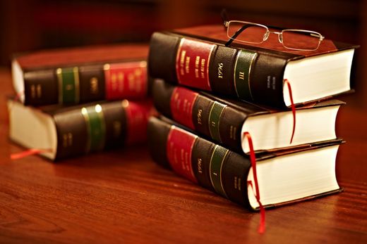 A stack of books with glasses on top of them