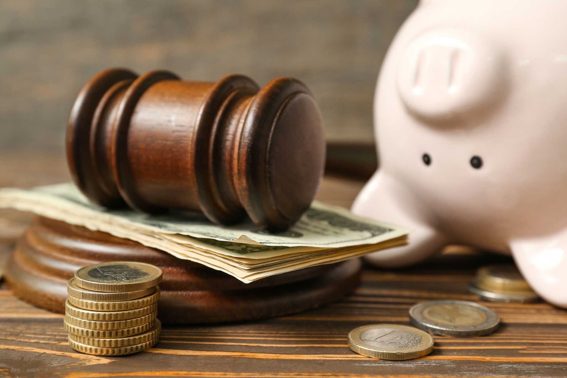 Piggy bank with judge gavel and money on brown wooden background. Piggy bank with judge gavel and money on brown wooden background.