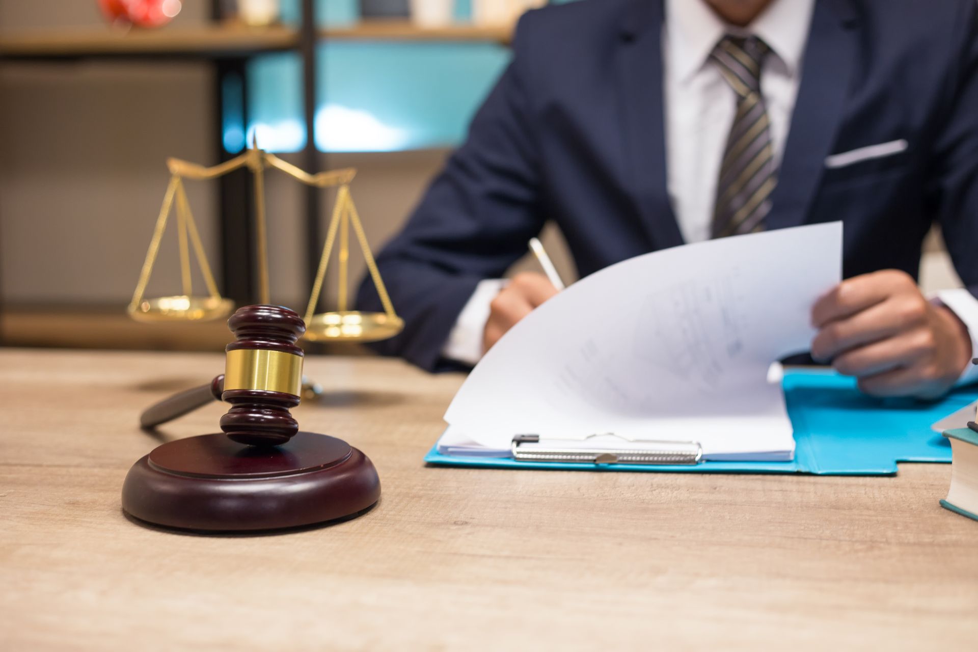 A personal bankruptcy attorney at a desk with a gavel and scales, representing law firm work.
