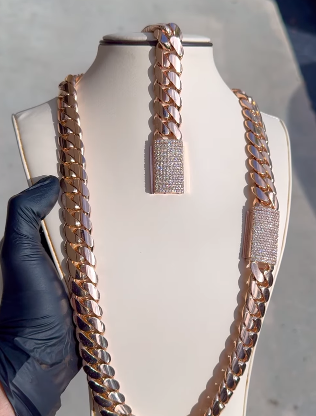 A person is holding a necklace and bracelet on a mannequin