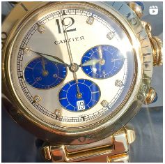 A gold cartier watch with a blue face