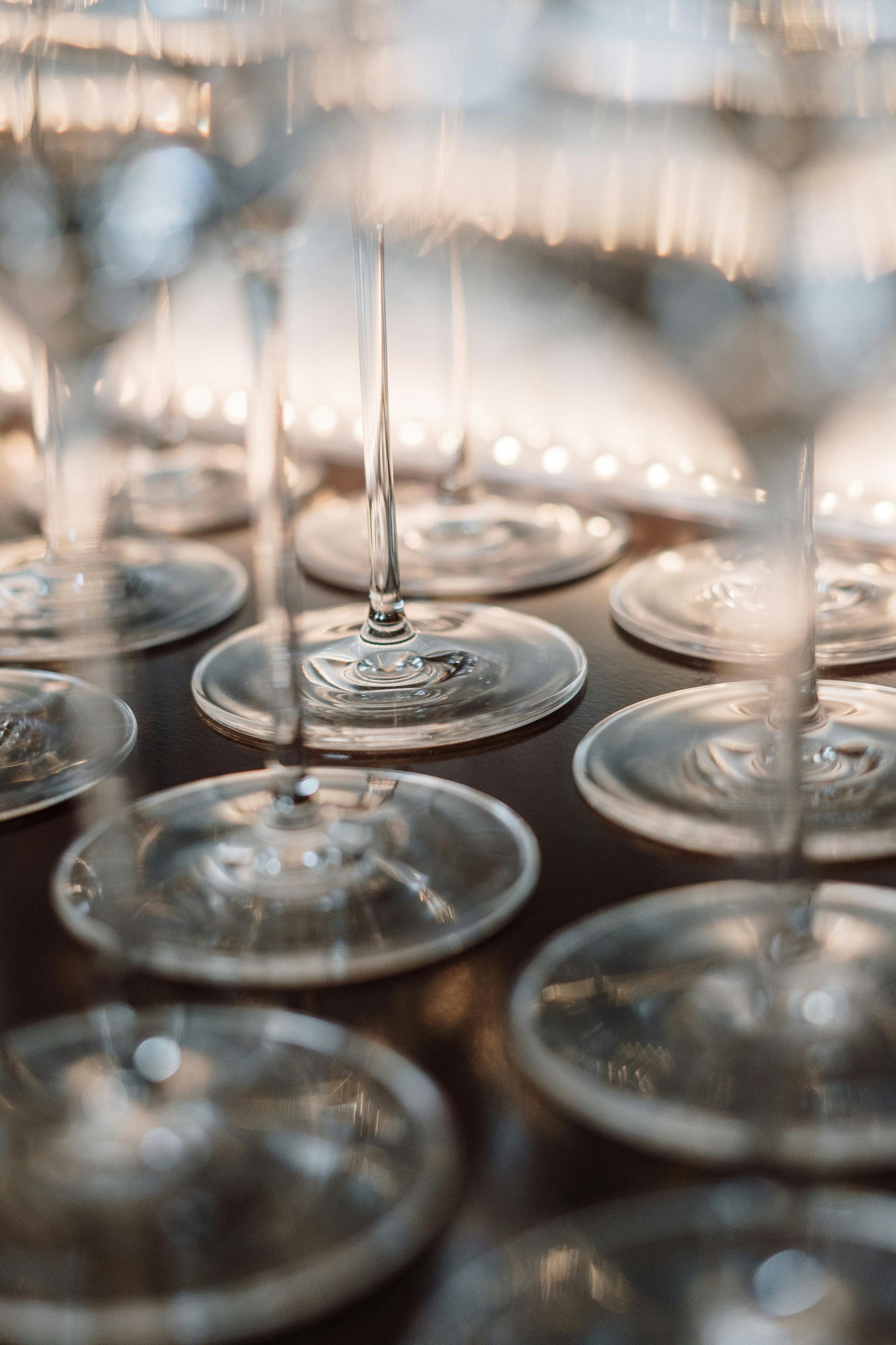 Une rangée de verres à vin posée sur une table en bois.