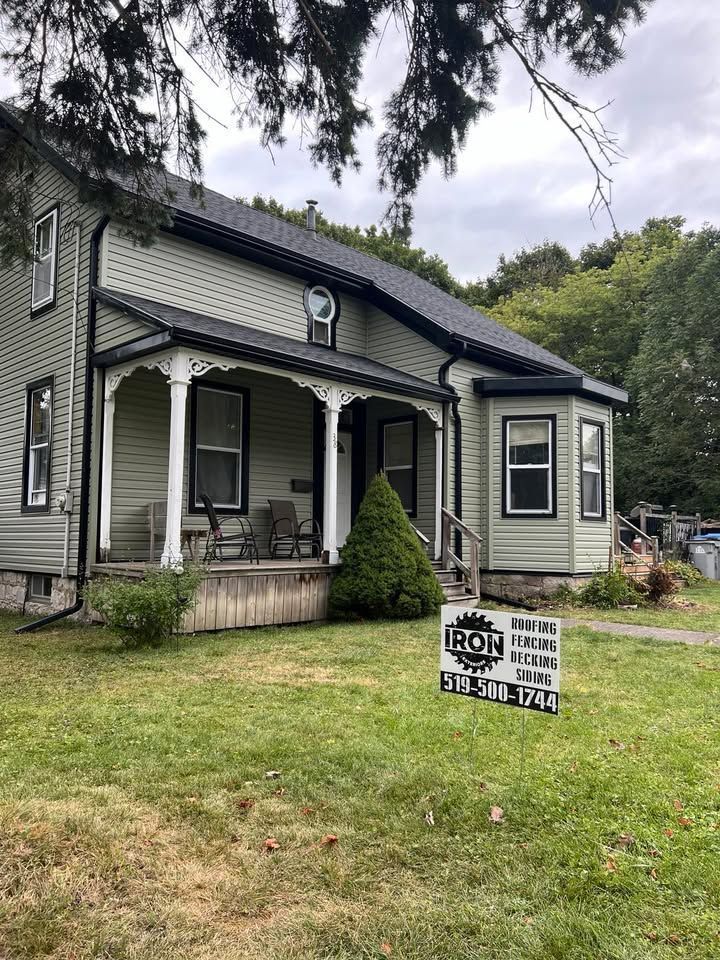 A house with a porch and a sign in front of it.