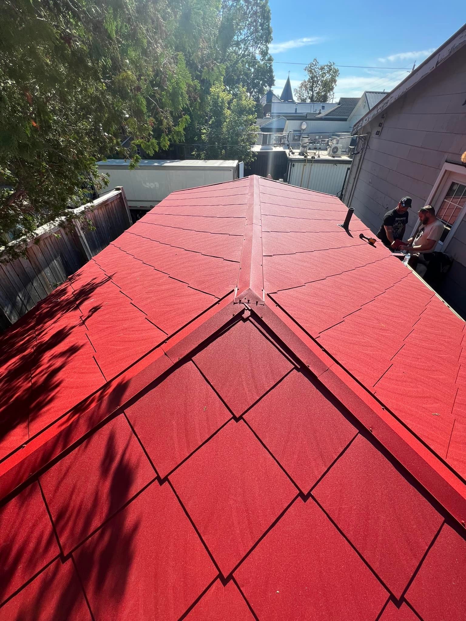 A red roof is being installed on a house.