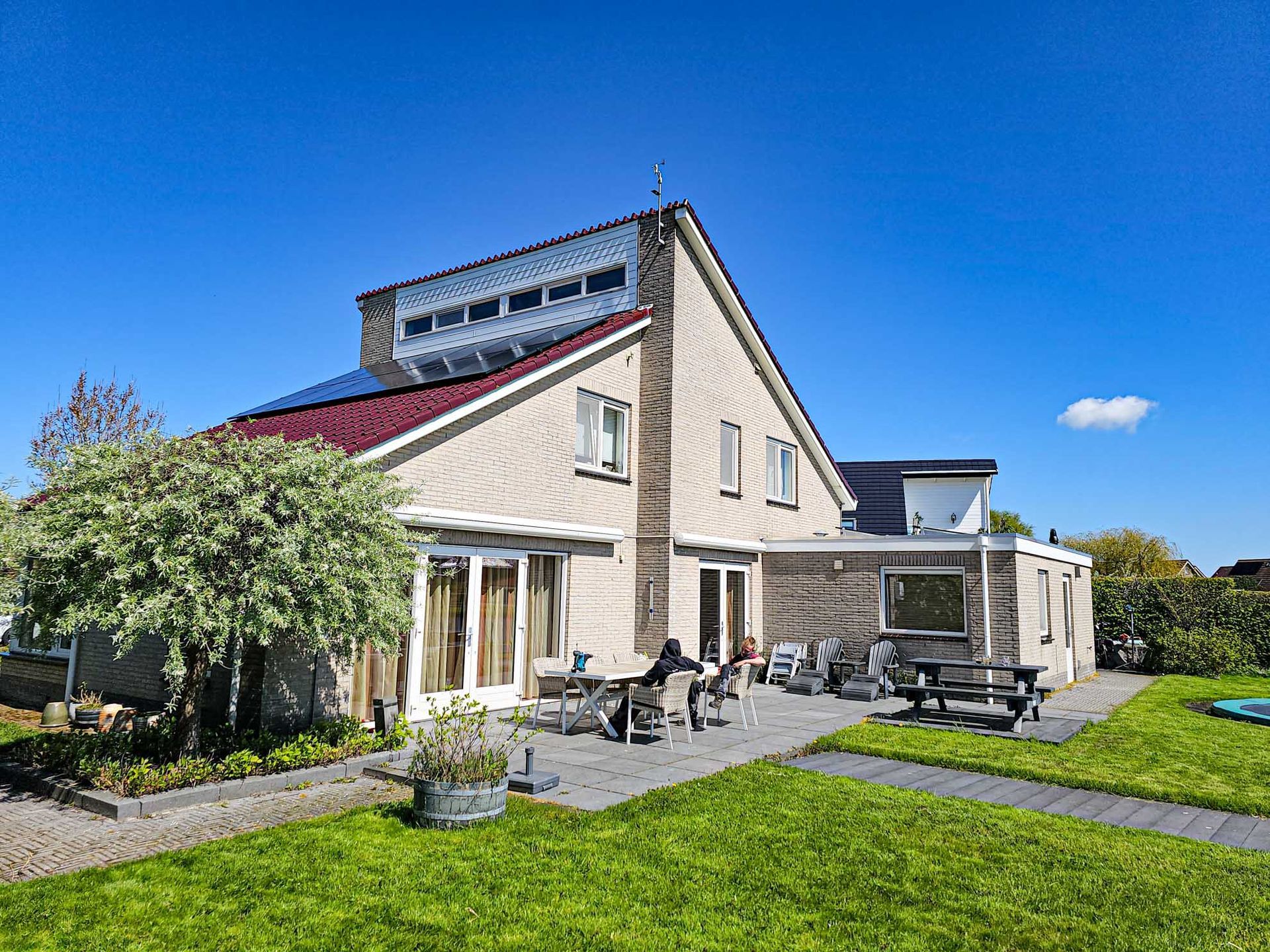 Een groot huis met een groot gazon ervoor.