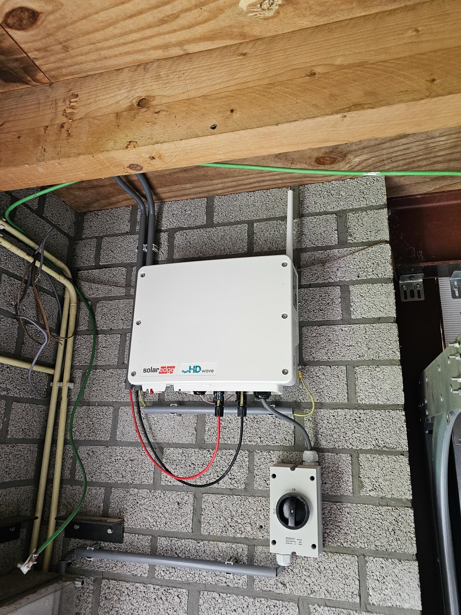 Een witte doos hangt aan een bakstenen muur.