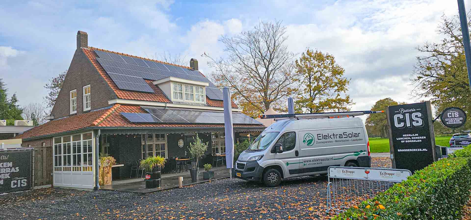 Een busje staat geparkeerd voor een huis met zonnepanelen op het dak.