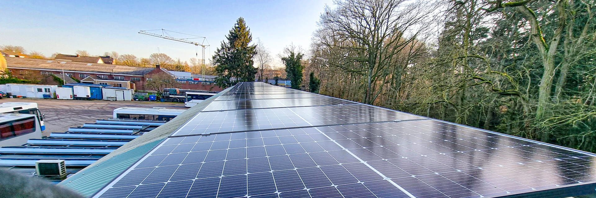 Er liggen veel zonnepanelen op het dak van een gebouw.