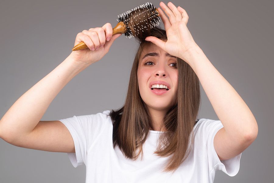 a woman holding a hair brush over her head
