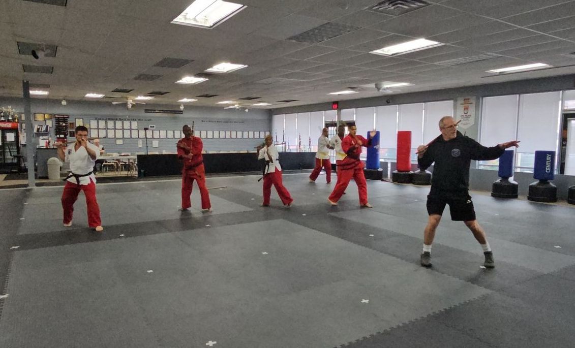 A group of people are practicing martial arts in a gym.