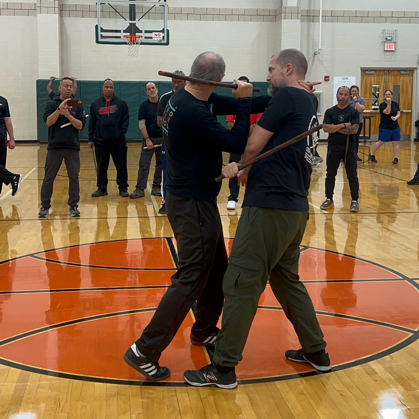 A group of men are practicing martial arts in a gym