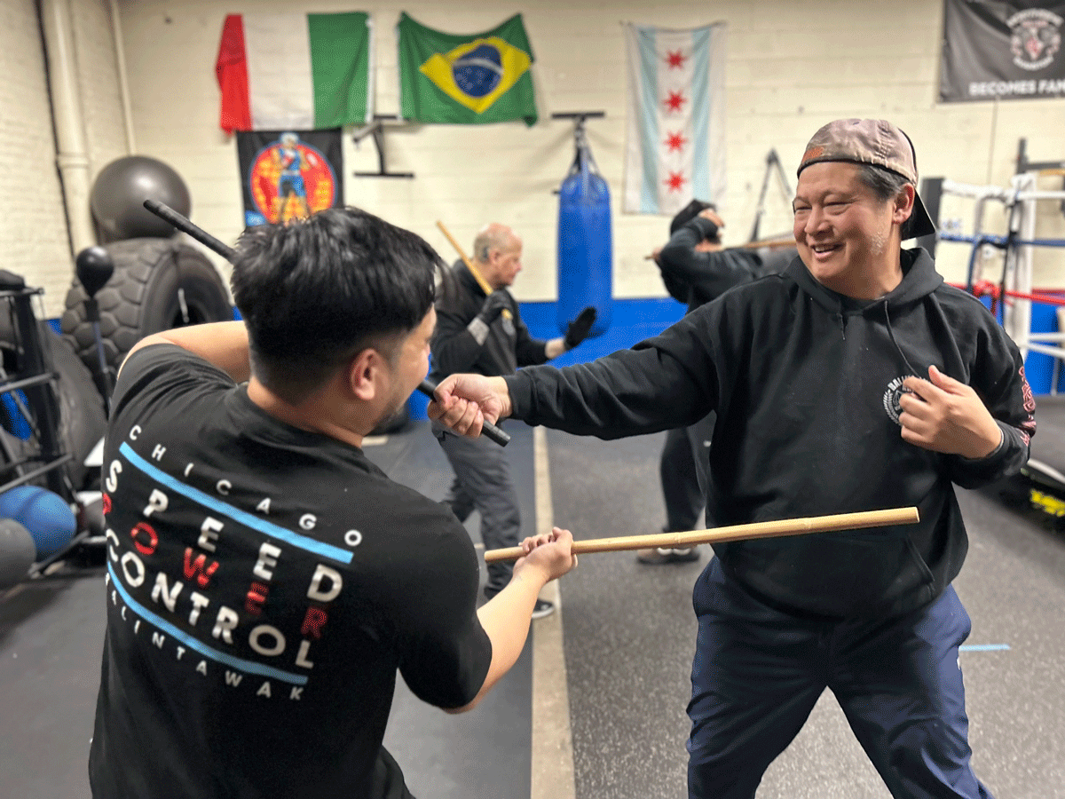 Two adult men smiling during Balintawak Martial Arts Class after a stressful work week