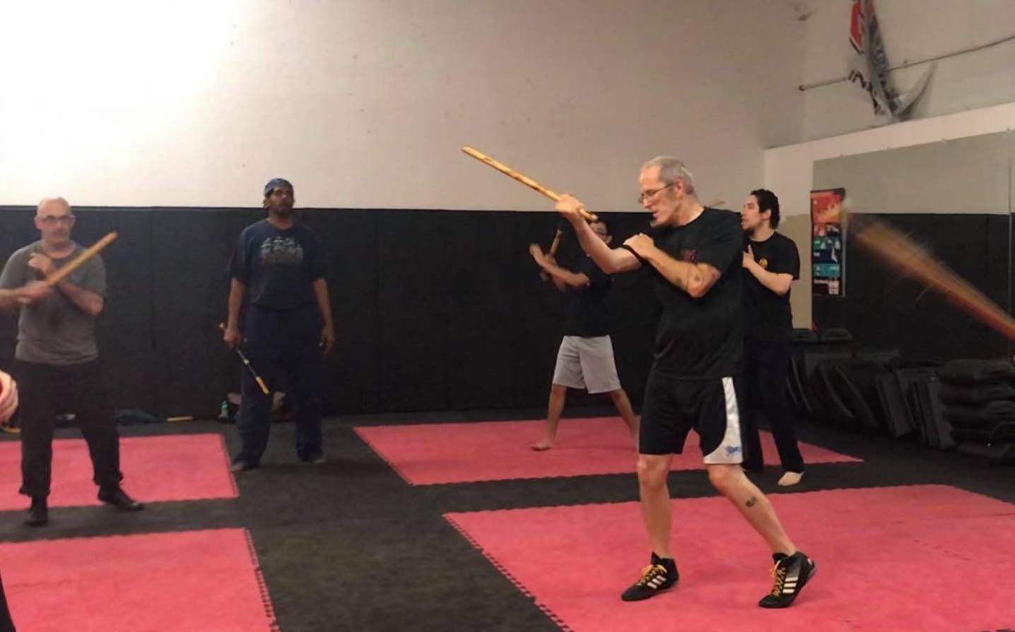 A group of men are practicing martial arts in a gym.