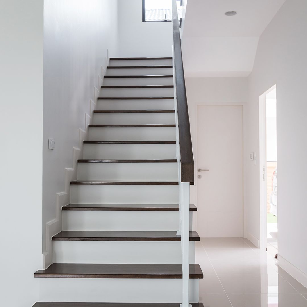 A white staircase with wooden steps and a white railing