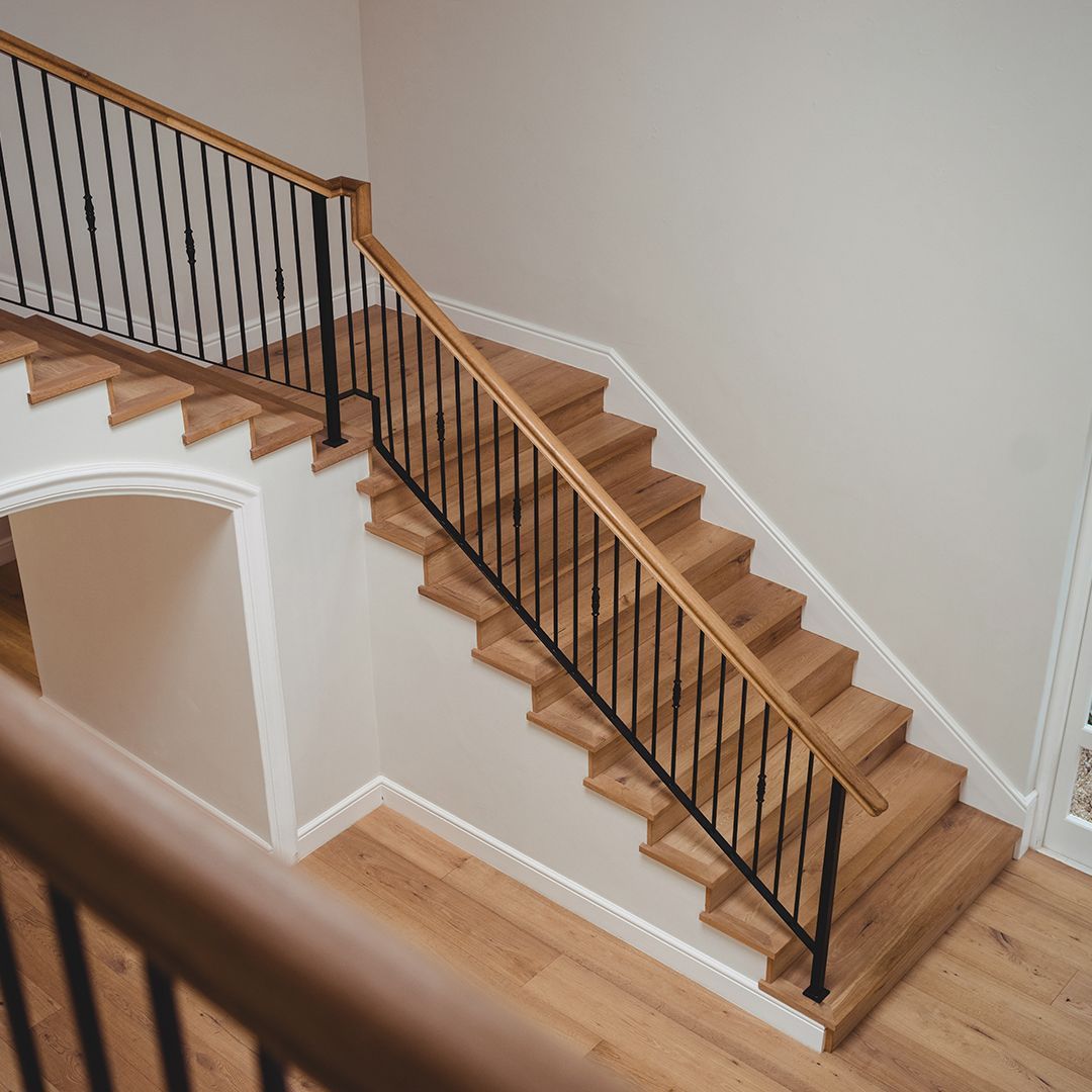 A wooden staircase with a metal railing in a house.