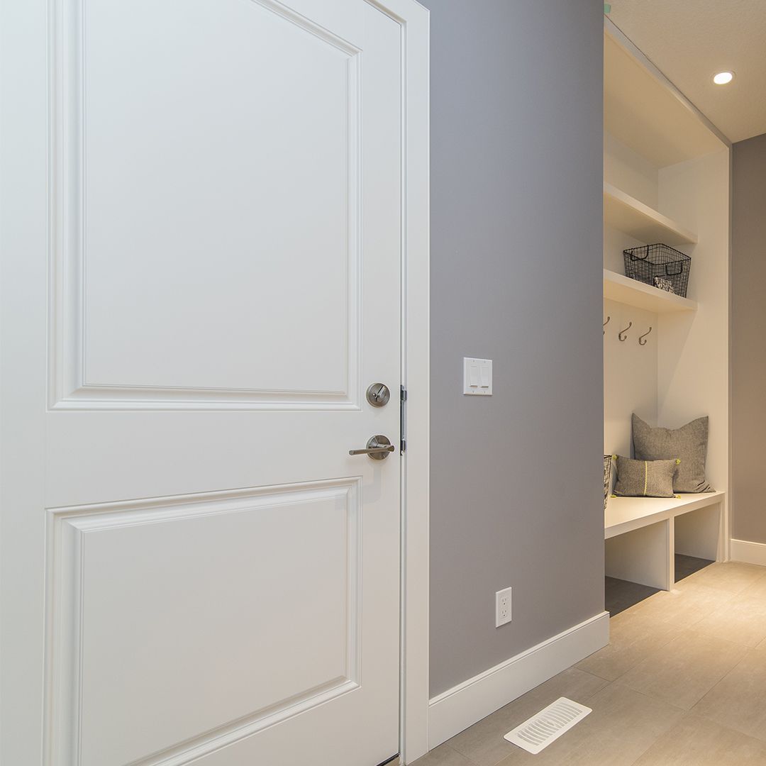 A hallway with a white door and a gray wall