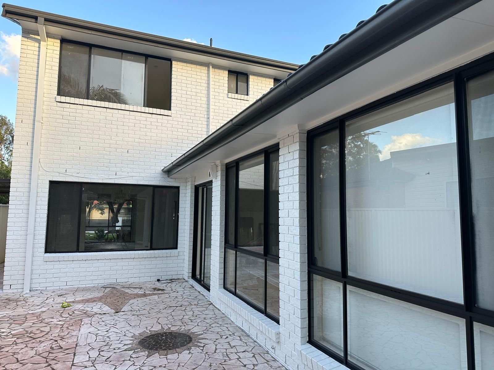 A white brick house with a lot of windows