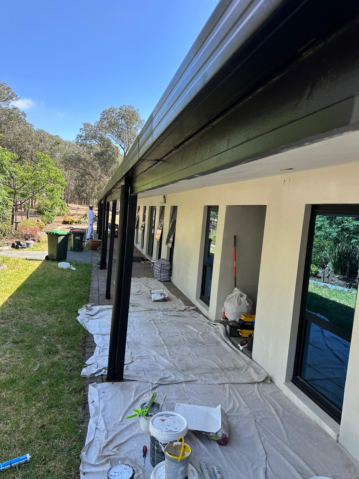 A house is being painted on a sunny day.