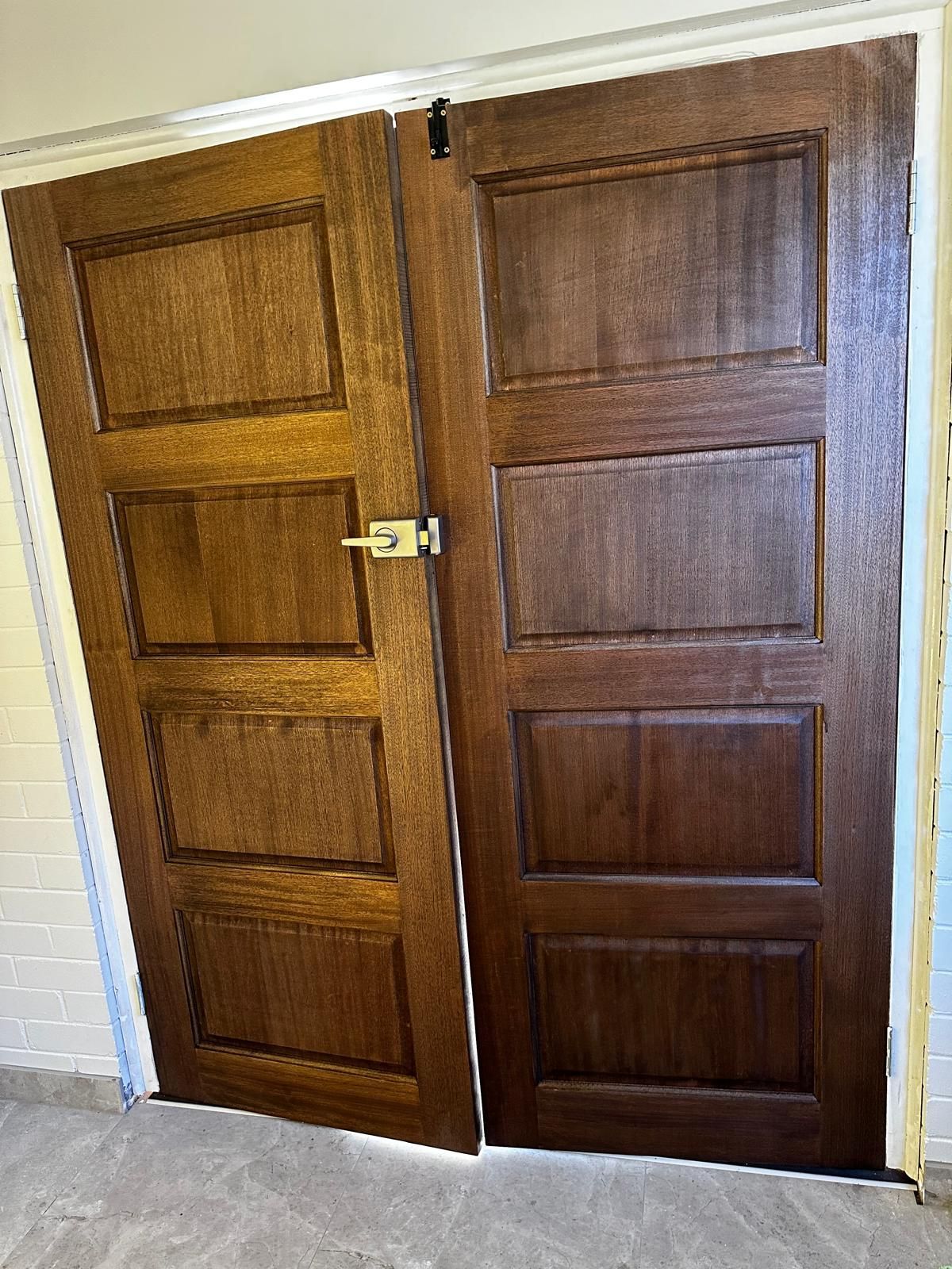 A pair of wooden doors are open in a room.