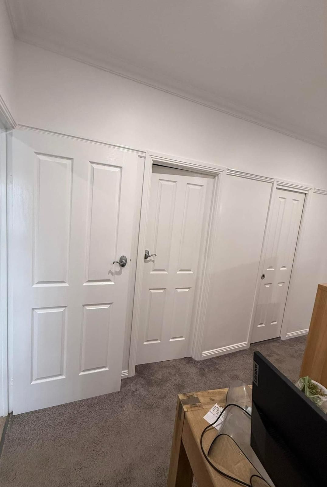 A room with a lot of white doors and a television.