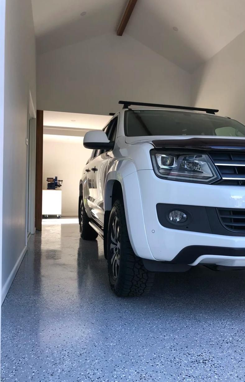 A white truck is parked in a garage.