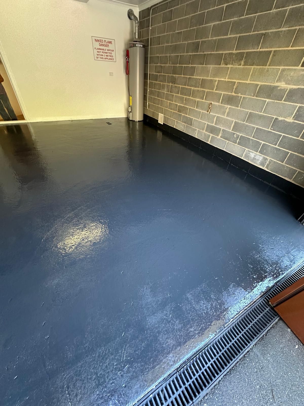 A garage with a brick wall and a black floor.