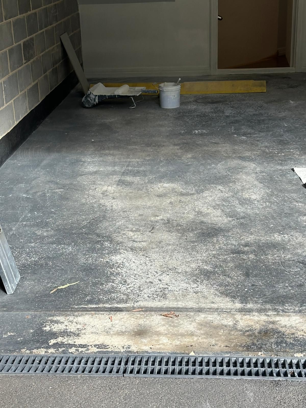 A dirty concrete floor in a garage with a drain.