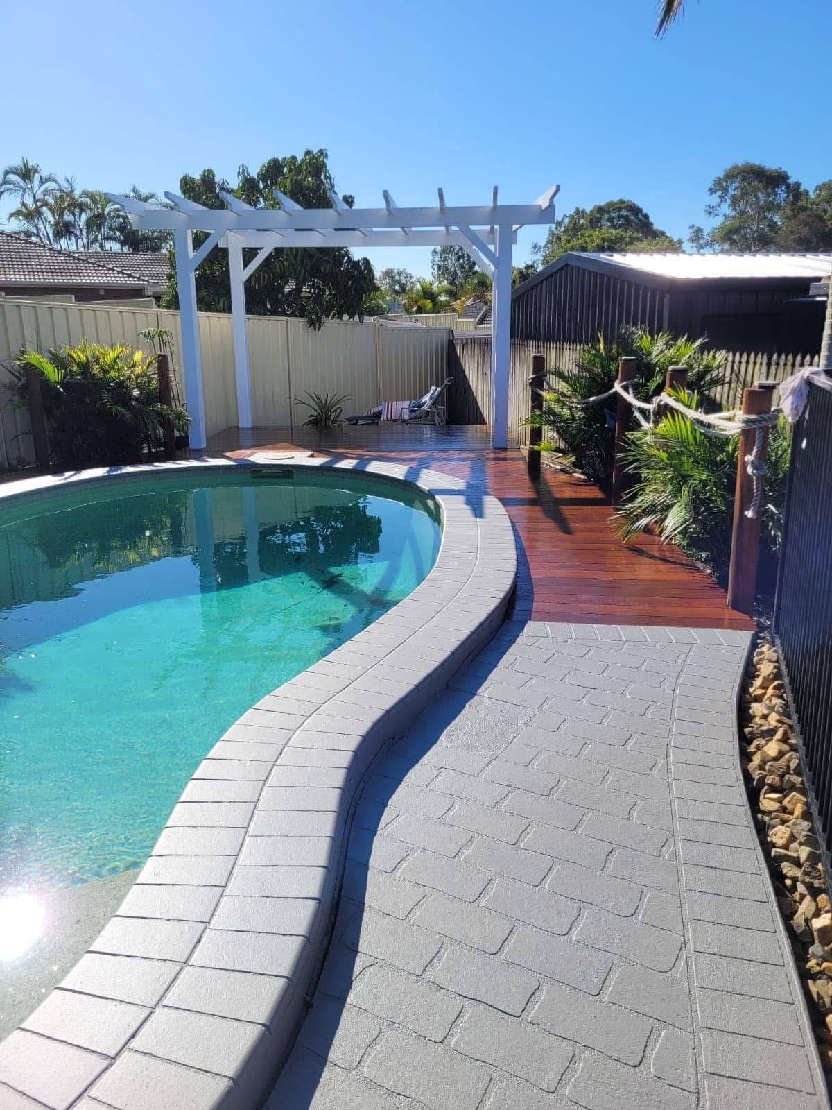 A swimming pool with a wooden walkway leading to it