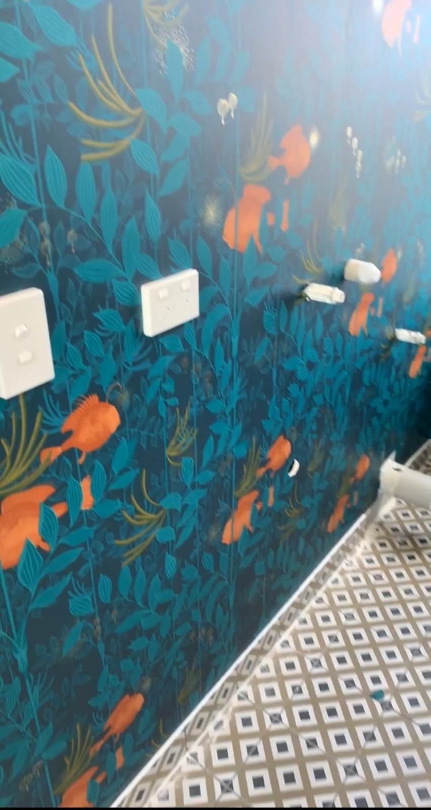 A bathroom with a staircase and a wall with a painting of fish on it.