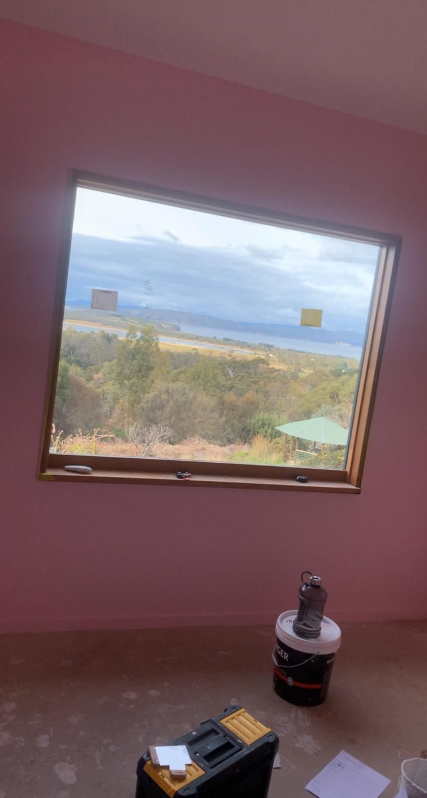 A room with a large window and a view of the ocean.
