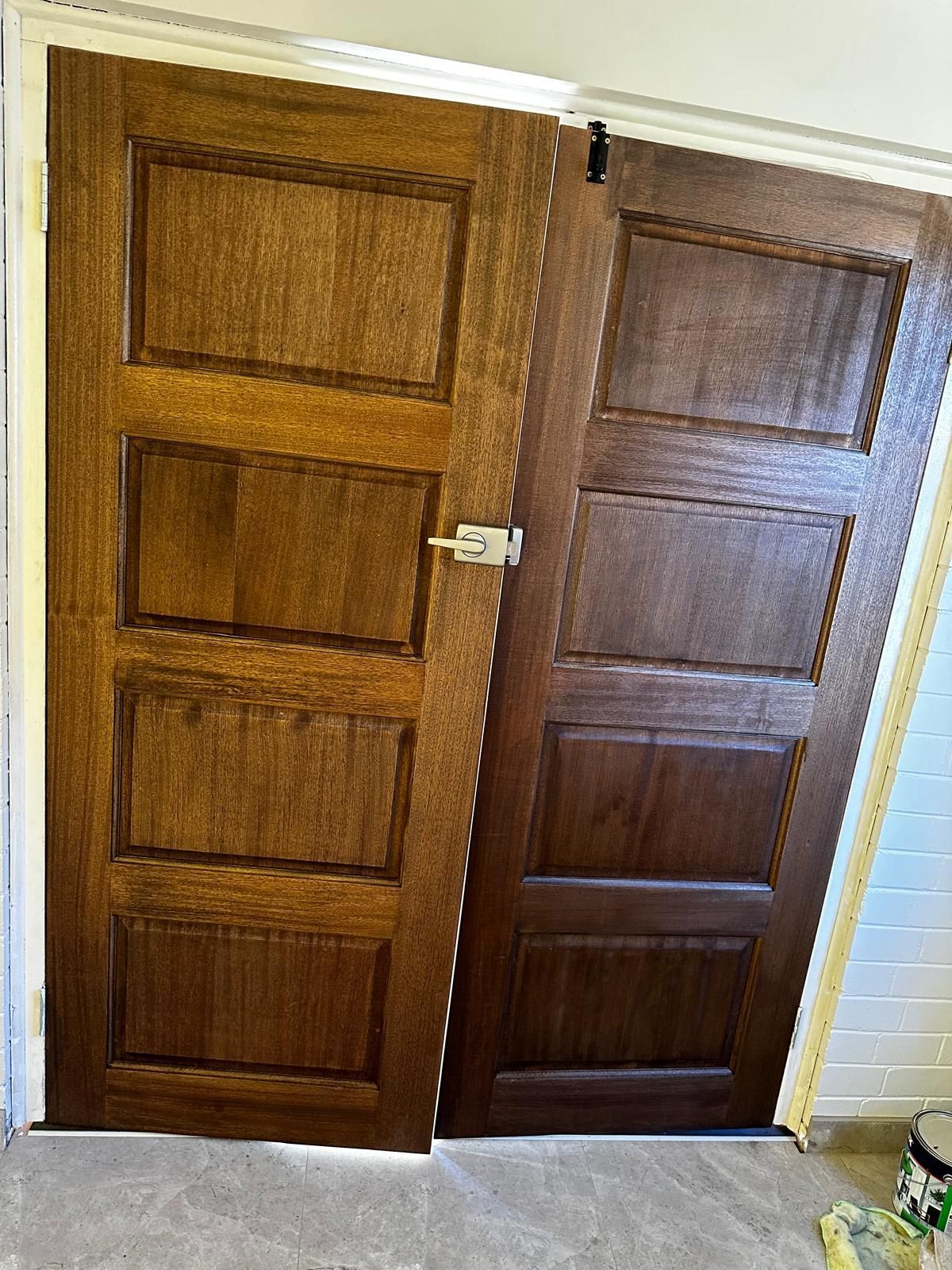 Two wooden doors are sitting next to each other in a room.