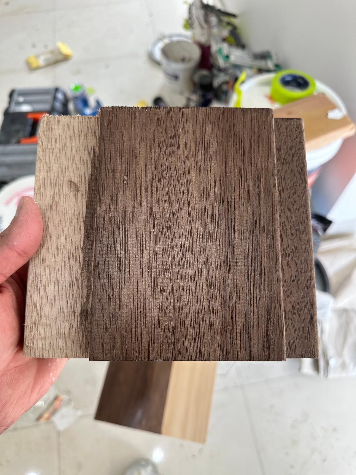 A person is holding a piece of wood in their hand.